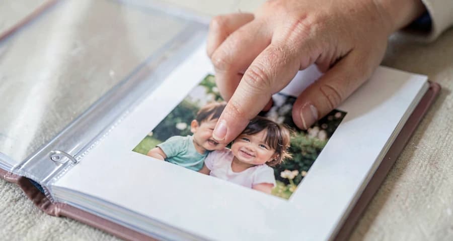 mão de bebê tocando foto de família em atividade de reconhecimento na creche