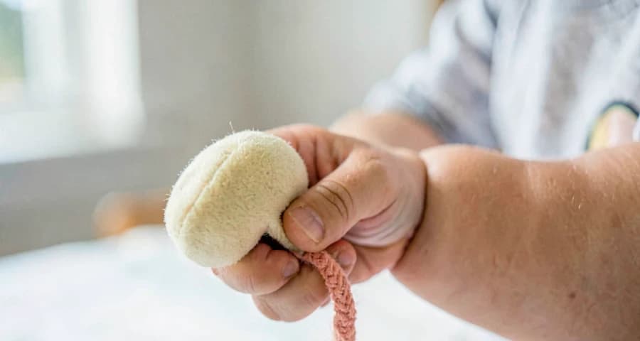 bebê segurando chocalho durante atividade de música clássica na creche