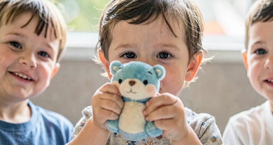 criança da creche mostrando brinquedo favorito trazido de casa
